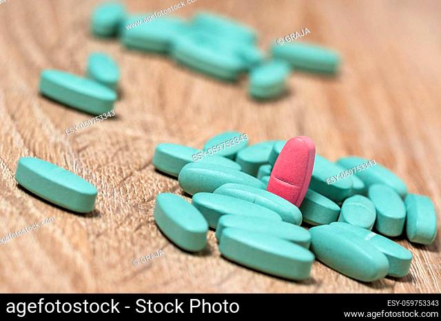 Individuality concept. Red medical pill in a pile of blue pills