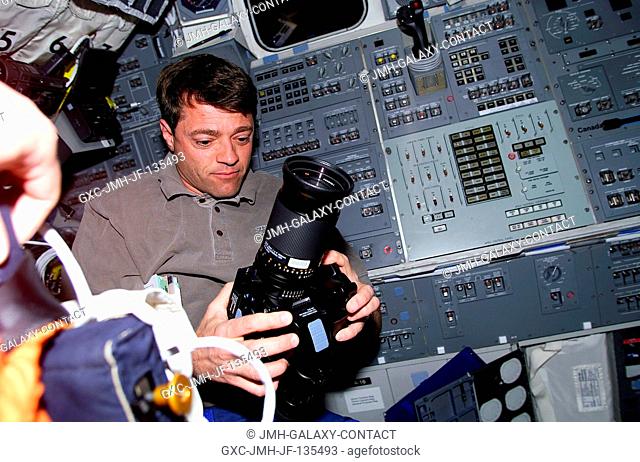 Astronaut Jeffrey S. Ashby, pilot, prepares to use a camera for out-the-window imagery from the aft flight deck of the Earth-orbiting Space Shuttle Endeavour