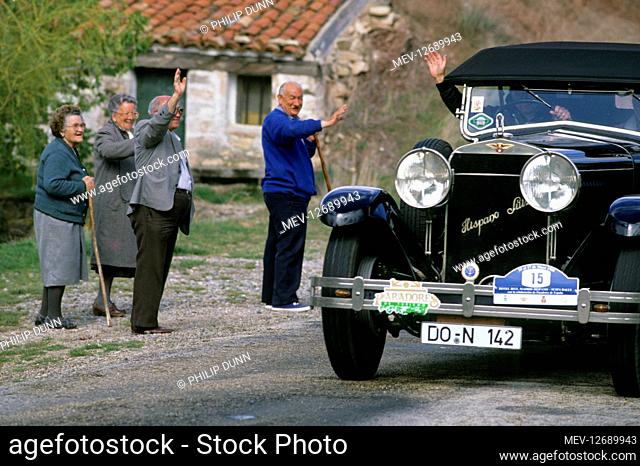 Hispano Suiza car rally - Santander to Madrid. Local people wave to the driver of a vintage Hispano Suiza car as it passes though a Spanish village during the...
