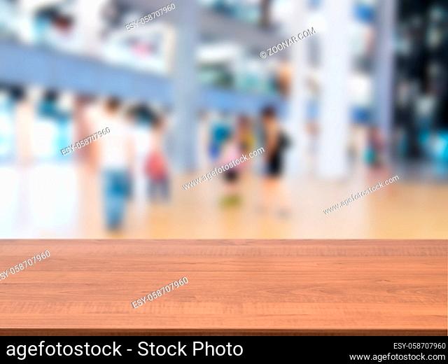 Wooden board empty table in front of blurred background. Perspective dark wood table over blur in shopping mall hall. Mock up for display or montage your...
