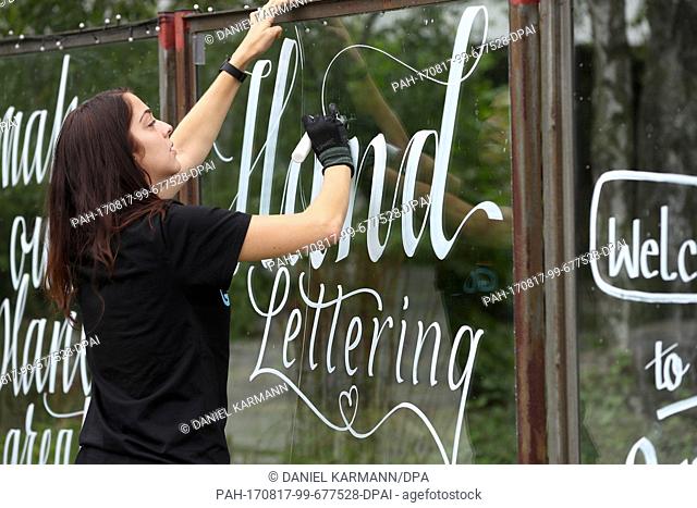 Nuremberg based artist and designer Hannah Rabenstein is painting on a window glass with white acrylic paint in Nuremberg, Germany, 10 August 2017