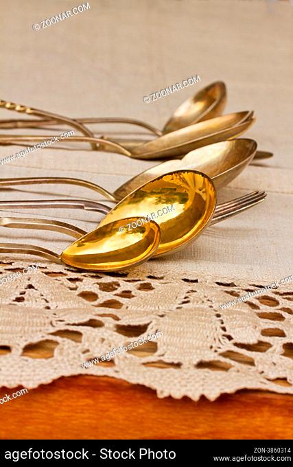 antique cutlery laying in row on linen tablecloth