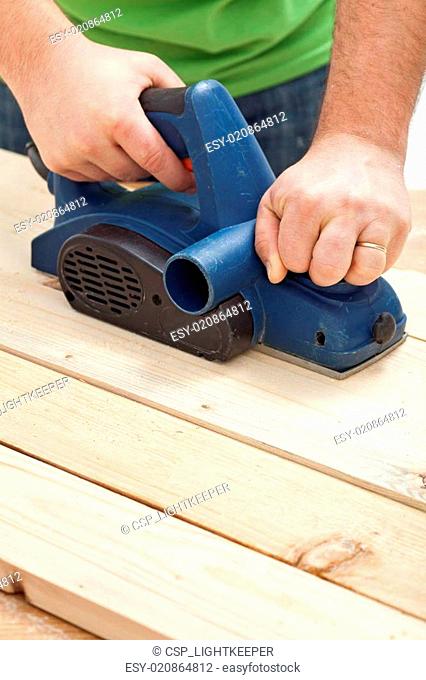 Construction worker hands with electric planer