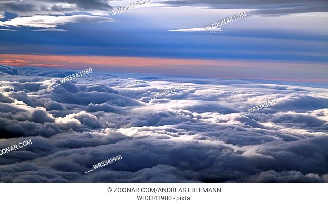 Flug über Alaska zwischen Wolken bei Sonnenaufgang