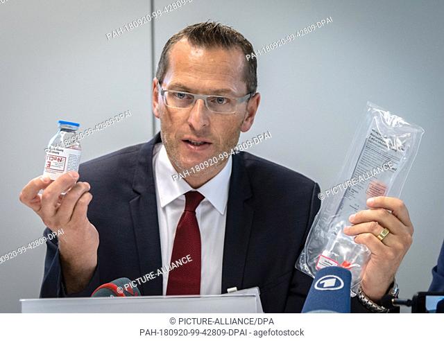 20 September 2018, Baden-Wuerttemberg, Goeppingen: Dr. Ingo Hüttner, medical managing director of Alb Fils Kliniken GmbH shows a bottle with NaCl infusion...