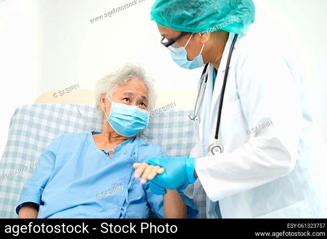 Doctor help Asian senior or elderly old lady woman patient wearing a face mask in hospital for protect safety infection and kill Covid-19 Coronavirus