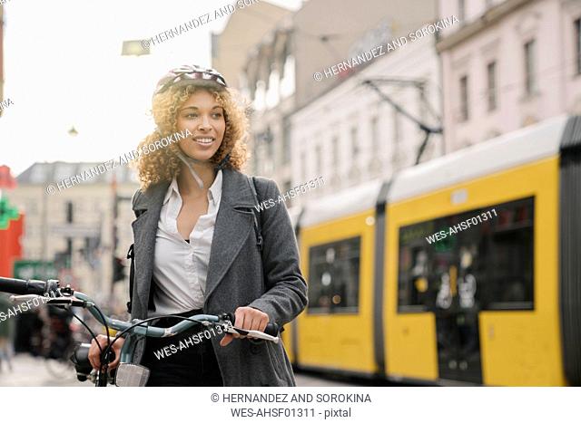 Woman with bicycle in the city, Berlin, Germany