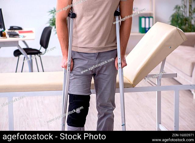 Young leg injured man with the crutches