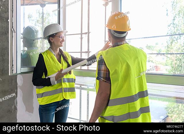 Construction workers inspecting windows on site of building