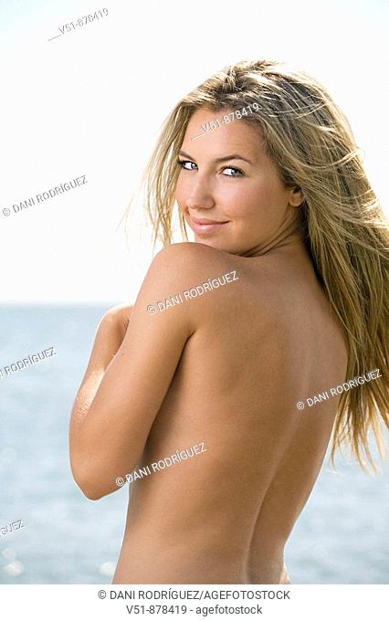 Sexy blonde woman at the beach looking at camera