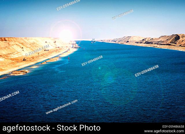 Der Suezkanal - Militärschiff und Schlepper fahren im 2015 neu eröffneten Erweiterungskanal, ausgehobene Sandberge türmen sich an den Seiten, Blendenreflex