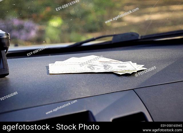 Dollars on a car dashboard under the windshield. American Money