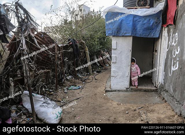 26 January 2022, Palestinian Territories, Beit Lahia: A Palestinian child stands in front of his house during the cold weather of the winter season in the...