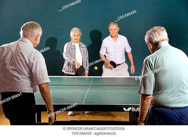 Senior men and women ranging in age from their 70's to their 90's play ping pong at a seniors' athletic facility in the retirement community of Laguna Woods, CA