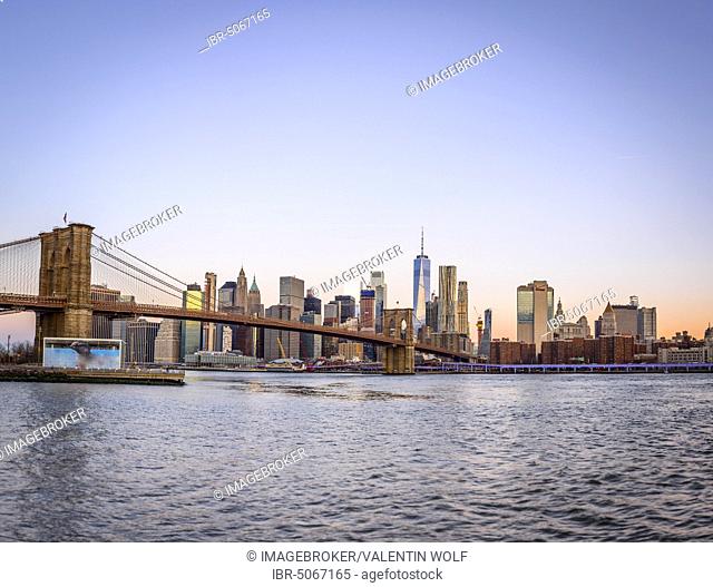 Brooklyn Bridge at sunrise, view from Main Street Park over the East River to the skyline of Manhattan with Freedom Tower or One World Trade Center, Dumbo