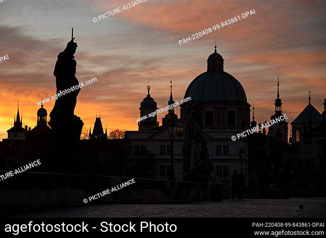 08 April 2022, Czech Republic, Prag: Vivid play of colors over the Charles Bridge. After a rainy and stormy night, the sky above the historic building shows...