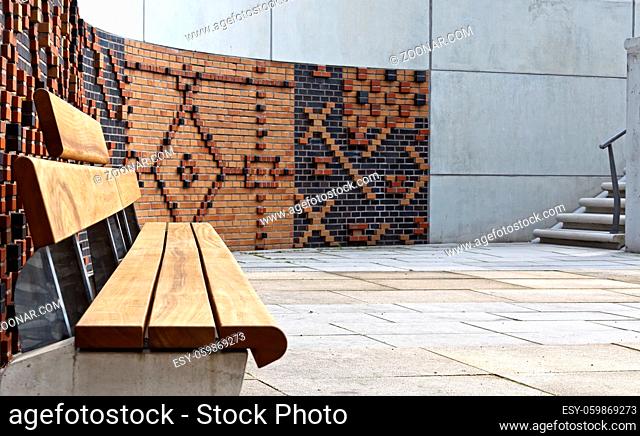 leere Sitzbank vor einer Stein- und Betonmauer in der Hamburger Hafencity, hamburg, Deutschland