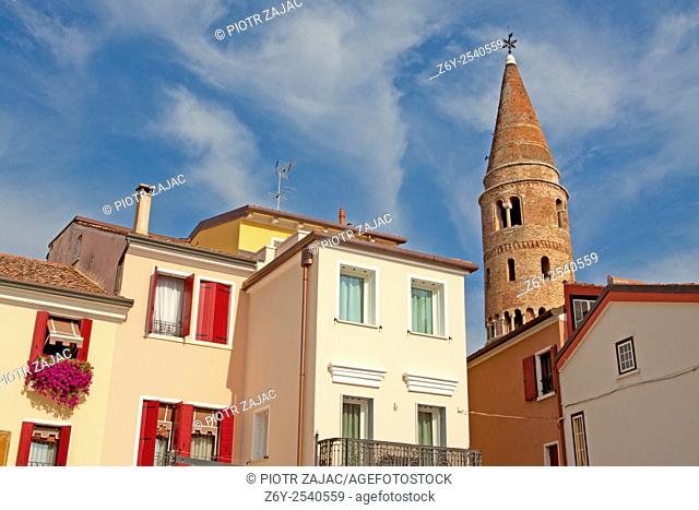 Coloured houses of the old town centre with the cathedral's bell tower in background in Caorle, Italy