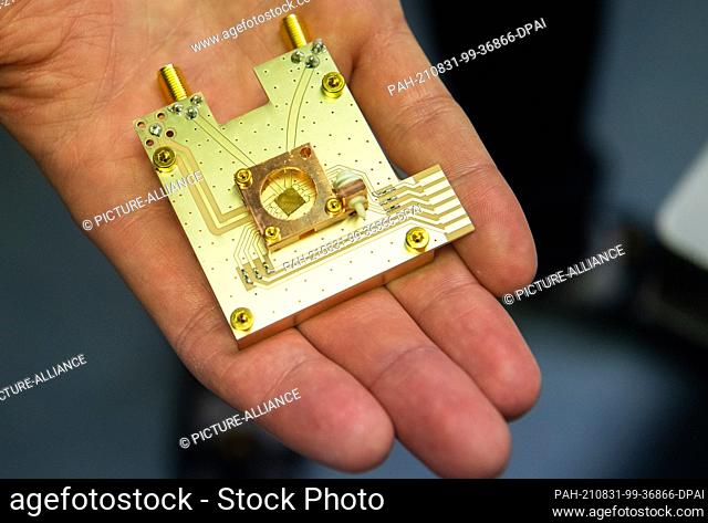 31 August 2021, Lower Saxony, Brunswick: Physicist Markus Duwe shows a quantum processor on a prototype of a quantum computer at the Physikalisch-Technische...