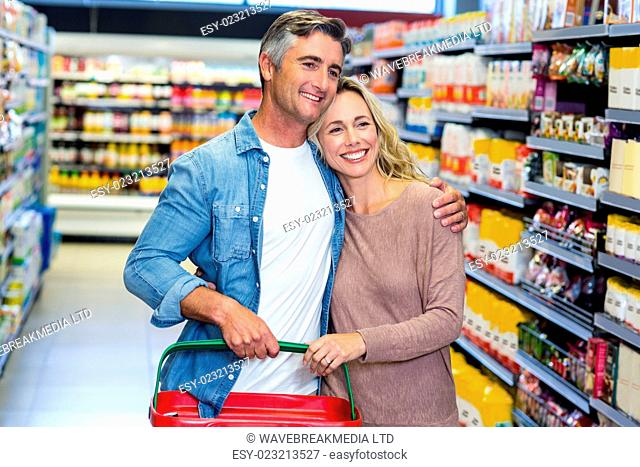 Happy smiling young couple doing shopping at supermarket