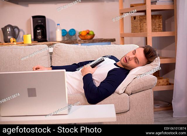 Freelancer taking nap during working process. Male in casual clothes sleeping at home, taking break from freelance work