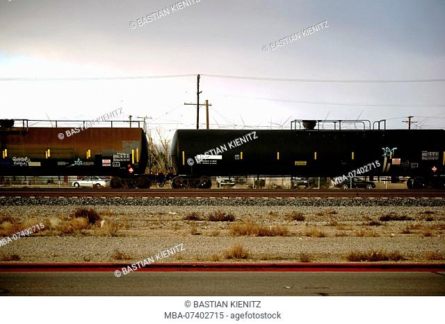 Freight train with tanks for transporting dangerous goods for chemical liquids on the tracks next to Mojave city
