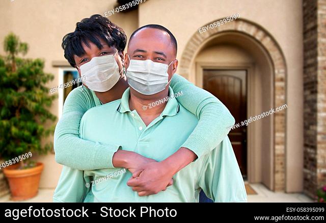 Loving African American Couple Hugging Wearing Medical Face Masks In Front of House