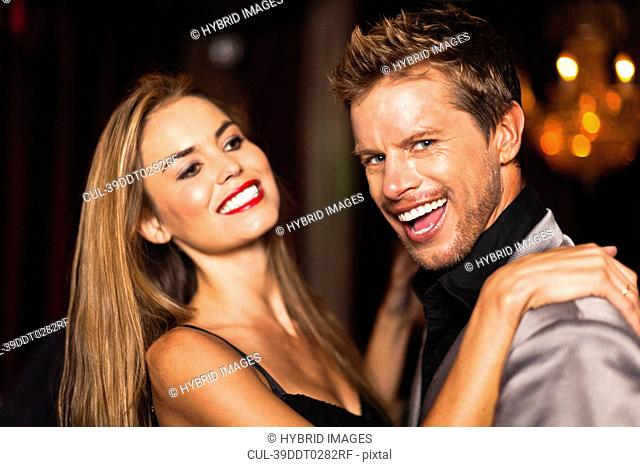 Smiling couple dancing in club
