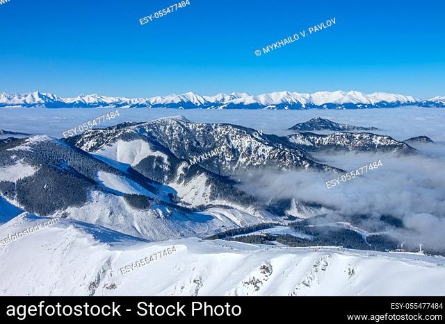 Ski resort Jasna. Winter Slovakia. Panoramic view from the top of the snow-capped mountains and fog in the valleys