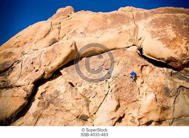 Girl rock climbing, Joshua Tree National Monument, California, USA