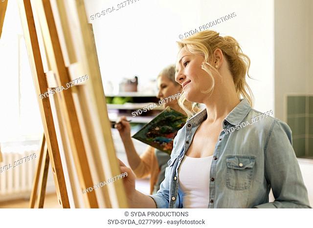 woman with easel drawing at art school studio