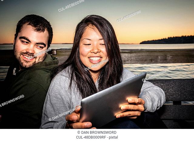Couple using tablet computer outdoors