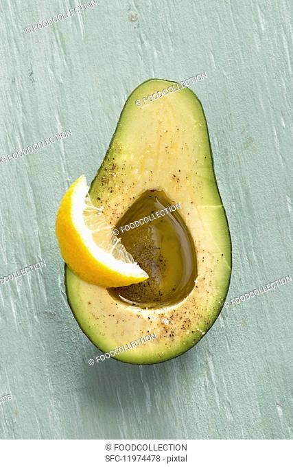 An avocado with olive oil and lemon