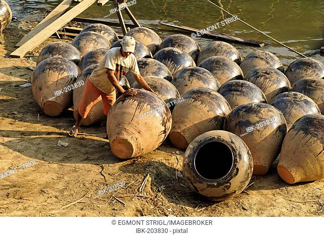 Man on the banks of Irrawaddy river with Martarban pots, Kyauk Myaung, Myanmar