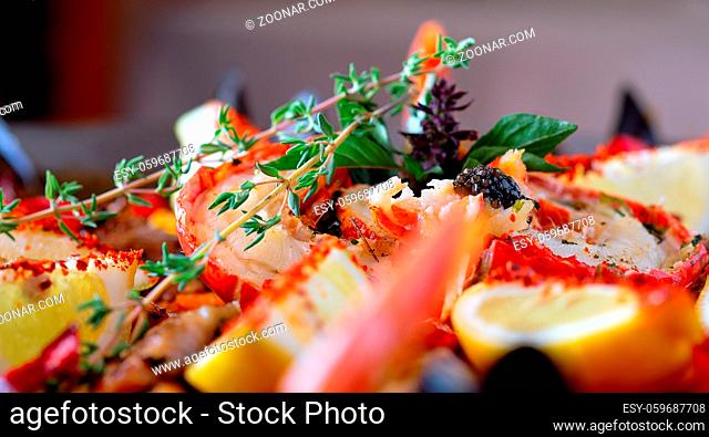 Close up image ripe ingredients of prepared served paella spanish traditional cuisine by country, bright colors. Dish garnished with lemon slices