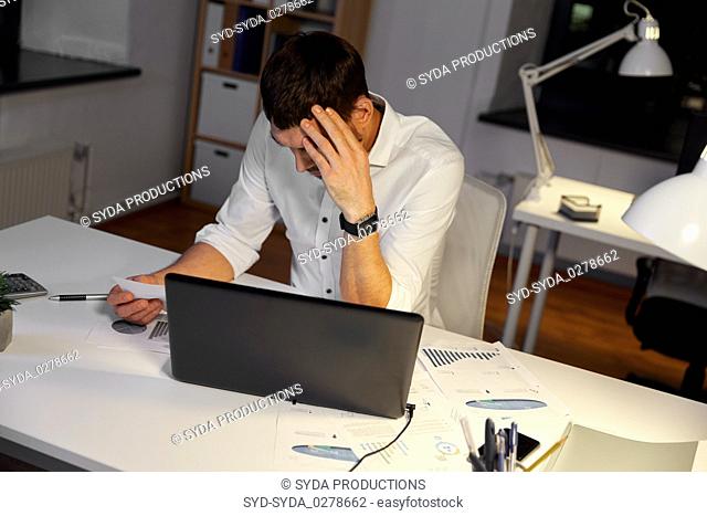 businessman with papers working at night office