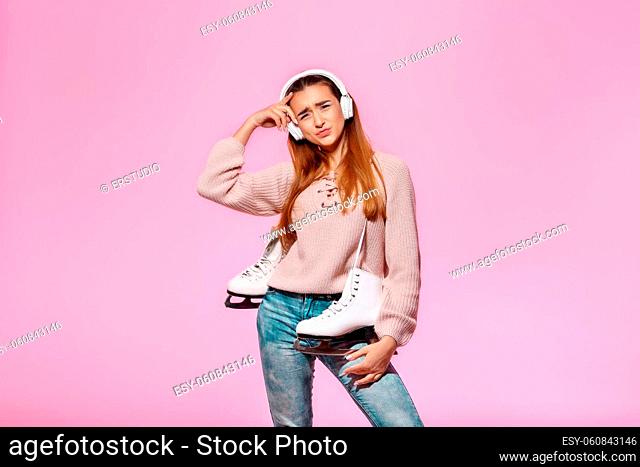 young indignant attractive woman holding ice skates