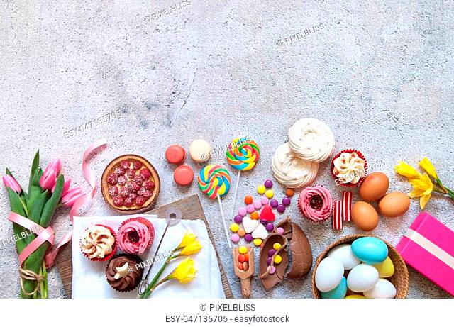 Selection of easter sweets, bakery cupcakes, chocolate eggs and confectionery with copy space