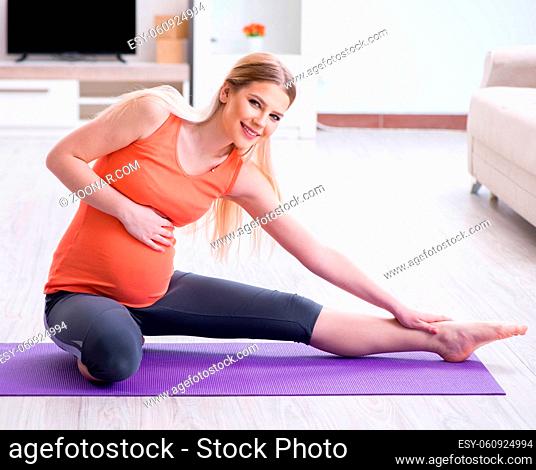 The pregnant woman doing sport exercise at home