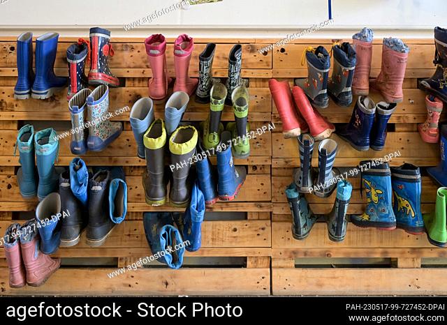 13 May 2023, Saxony-Anhalt, Halle (Saale): Rubber boots hang on a pallet wall at the Heide-Süd daycare center. The Heide-Süd daycare center took first place in...