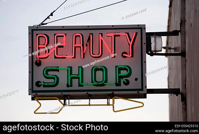 The beauty palor is closed but the neon sign is on