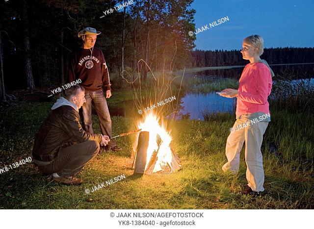 Hikers Companion by Campfire near Water in Night