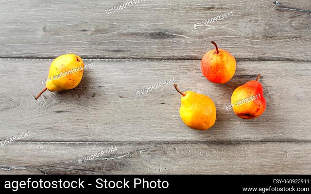 Table top view on four ripe pears placed on gray wood desk