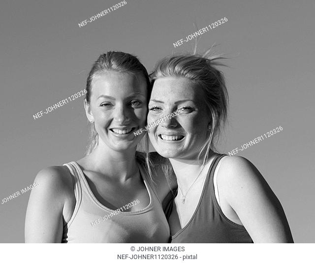 Two women standing with arm around, portrait