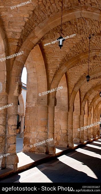 Exterior view of a christian churchyard historical buildindg passage with ancient columns and arches. Church is fronm Saint Lazaros in Larnaca, Cyprus