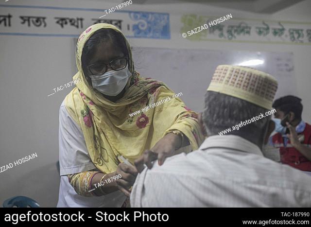 DHAKA, BANGLADESH - AUGUST 8: A health worker administers a dose of Moderna COVID19 vaccine to a person, during a mass vaccination campaign at a vaccination...