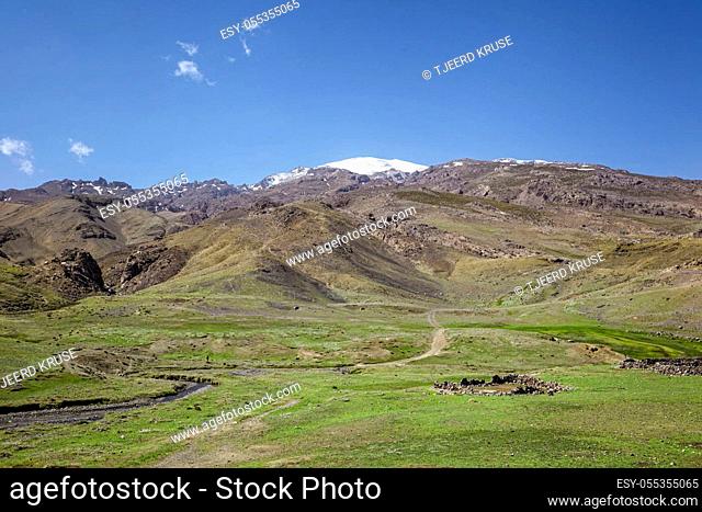 road in the high Atlas Mountains in Morocco, in the center of a small stone destroyed building