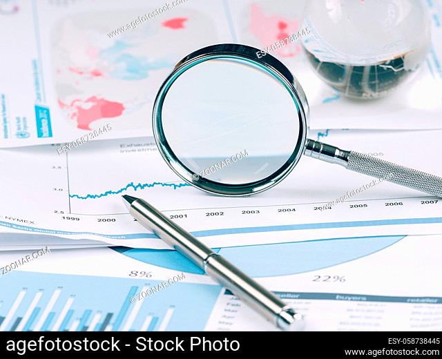 Business Data Analyzing, with magnifying glass and other on the desk