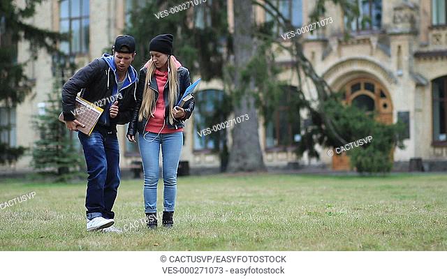 Cheerful students dancing on campus lawn