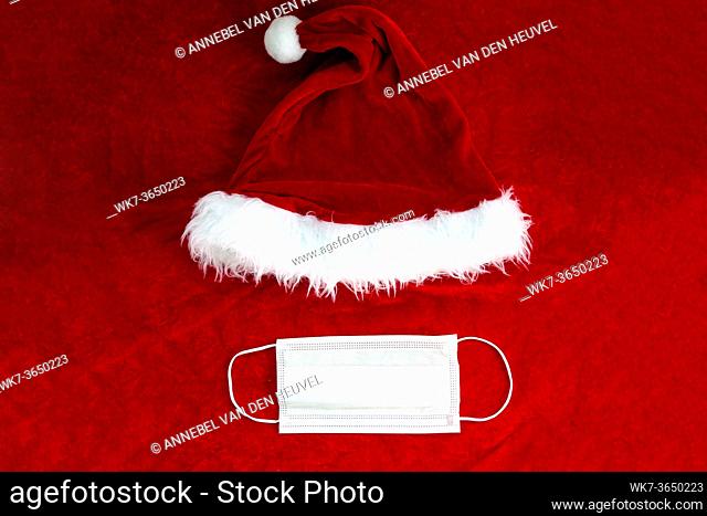 Santa Claus red hat with medical face mask on Santa Claus suit Fabric, Covid-19 and Christmas concept, background texture beauty